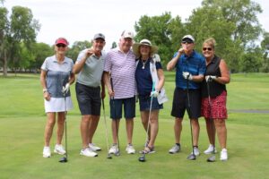 Golfers pose on the tee box at the Russ Hansen Memorial Scramble.