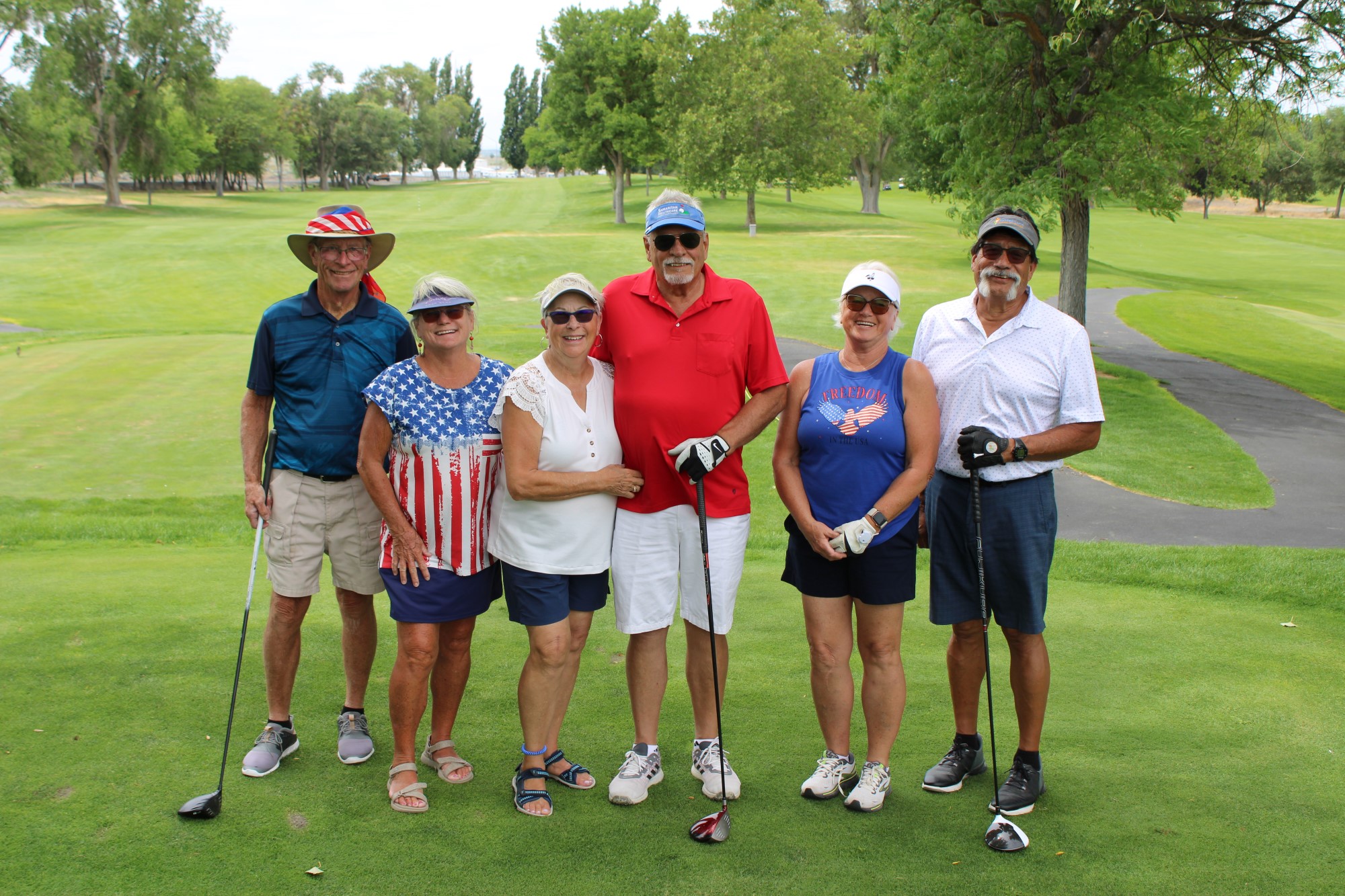 Golfers pose on the tee box at the Russ Hansen Memorial Scramble.