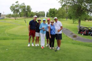 Golfers pose on the tee box at the Russ Hansen Memorial Scramble.