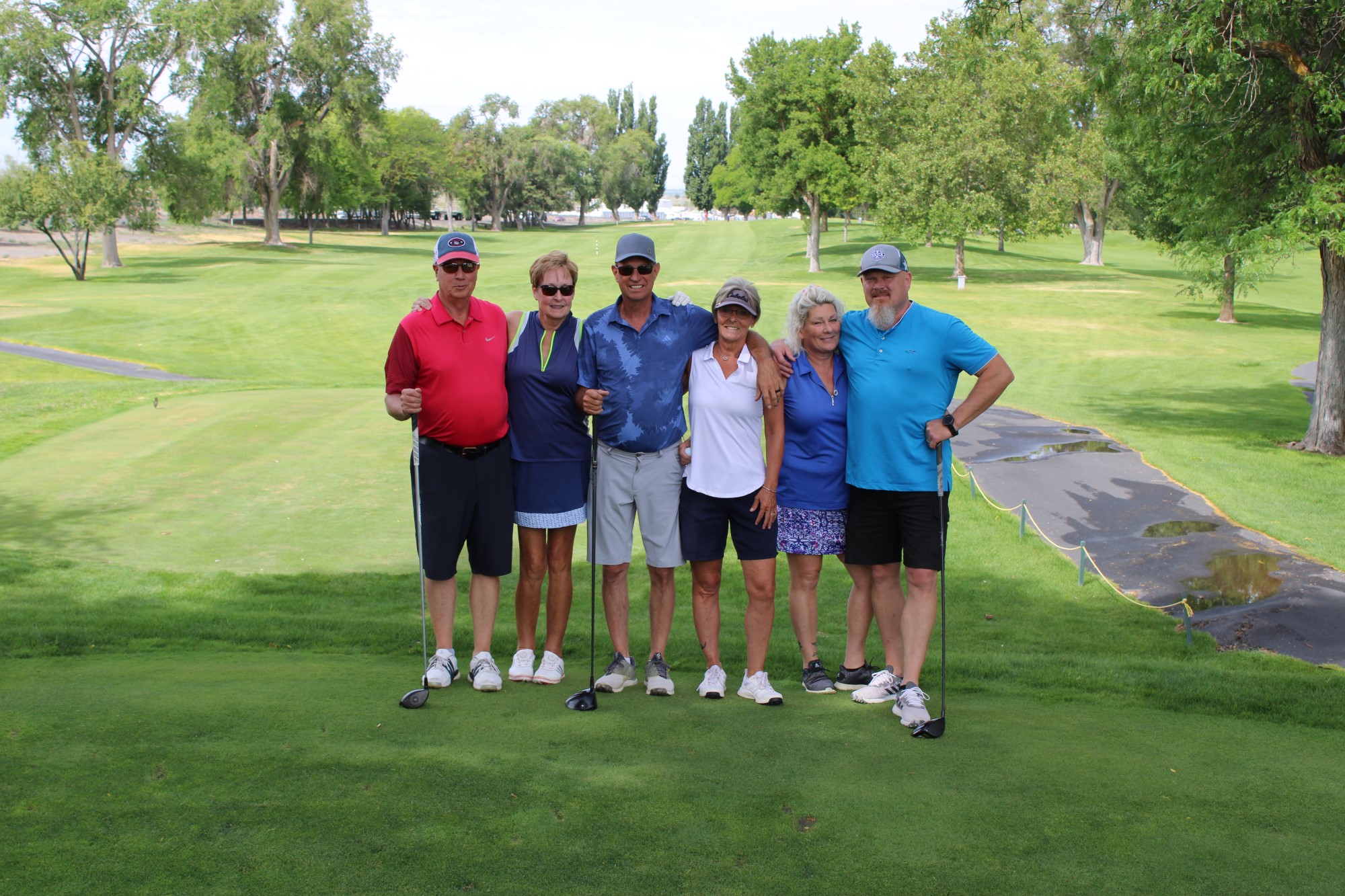 Golfers pose on the tee box at the Russ Hansen Memorial Scramble.